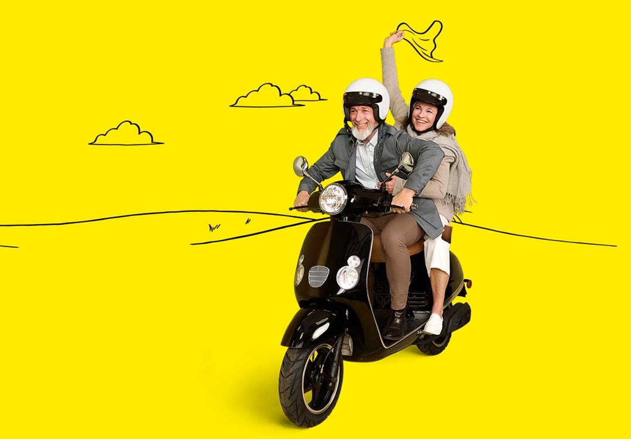 Couple wearing Interotn hearing aids and riding a motorbike.